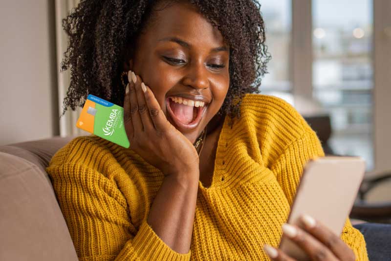 Woman excitedly holding a credit card, thrilled about a balance transfer intro rate promotion.