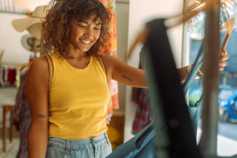 Young woman dress shopping at a local clothing boutique.