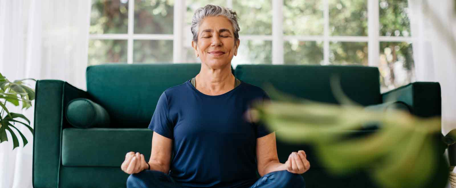 A woman meditating indoors, enjoying the financial peace of mind provided by a certificate