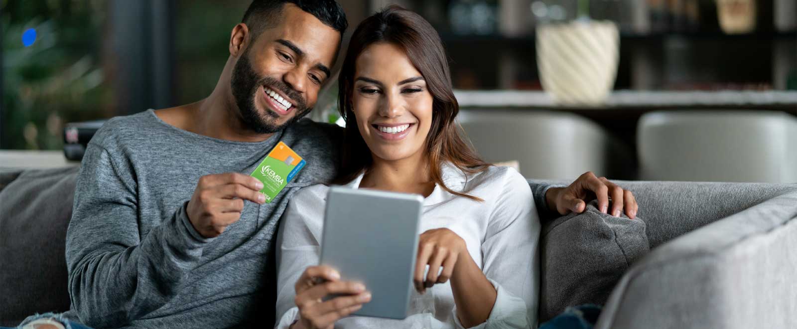 Couple shopping online on a tablet with a credit card