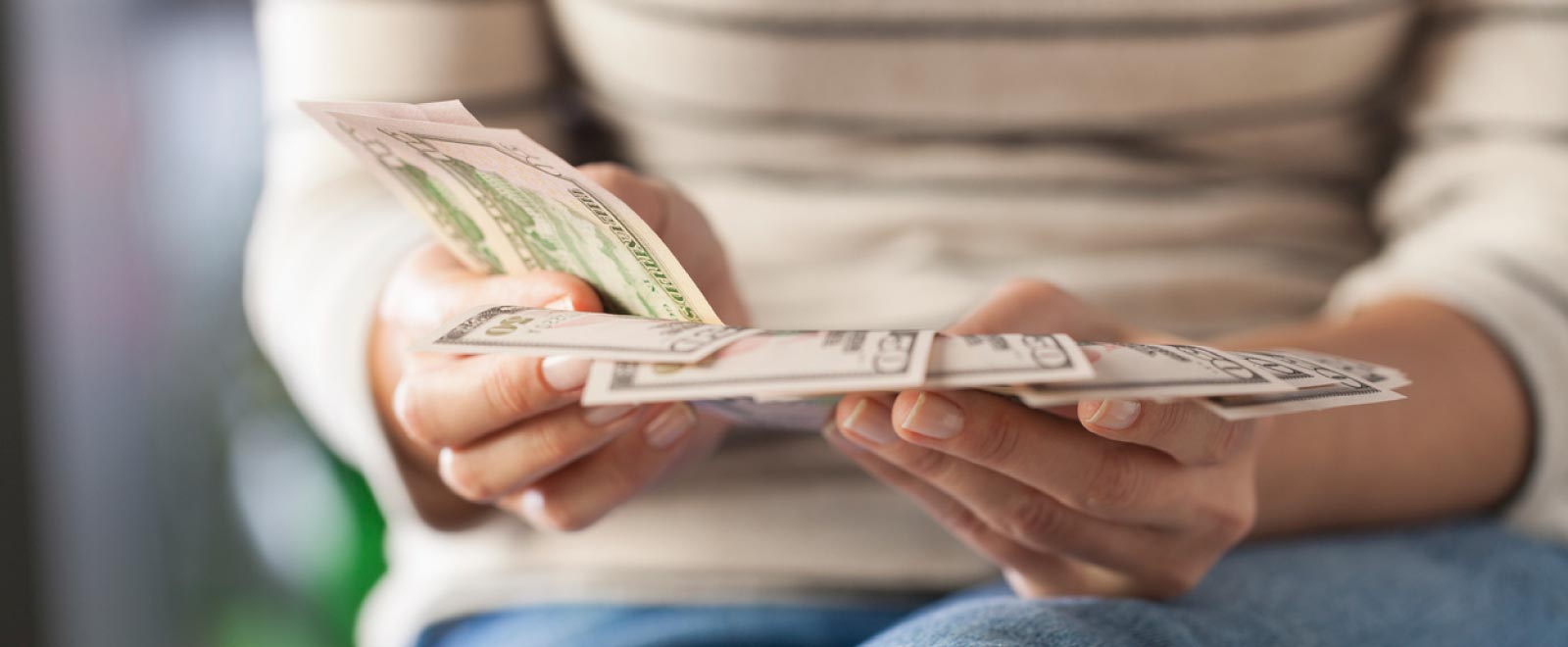 Woman counting paper money which represents the Money Market Account $300 bonus promotion