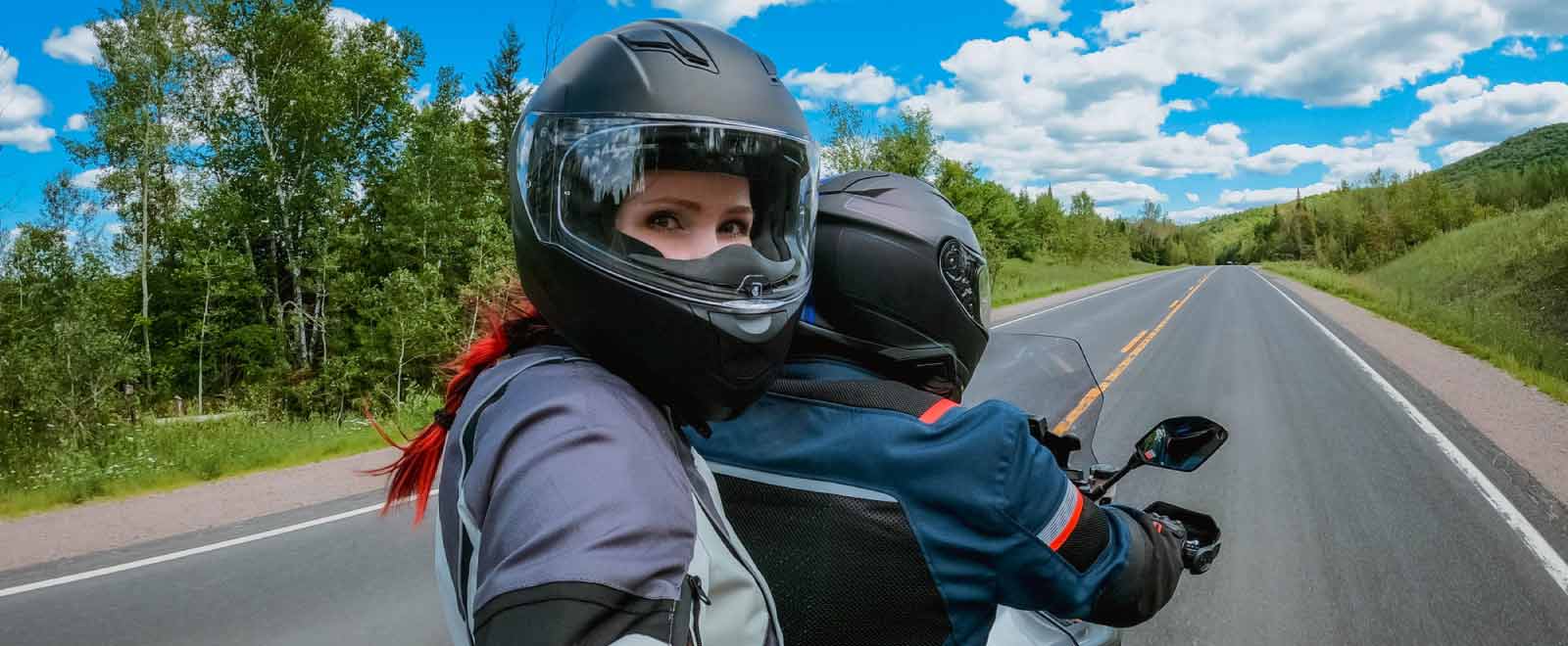 Two motorcyclists riding on an open road, showcasing freedom and adventure, representing affordable motorcycle loans available through KEMBA Financial.