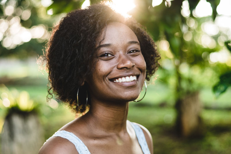 A woman smiling outside.