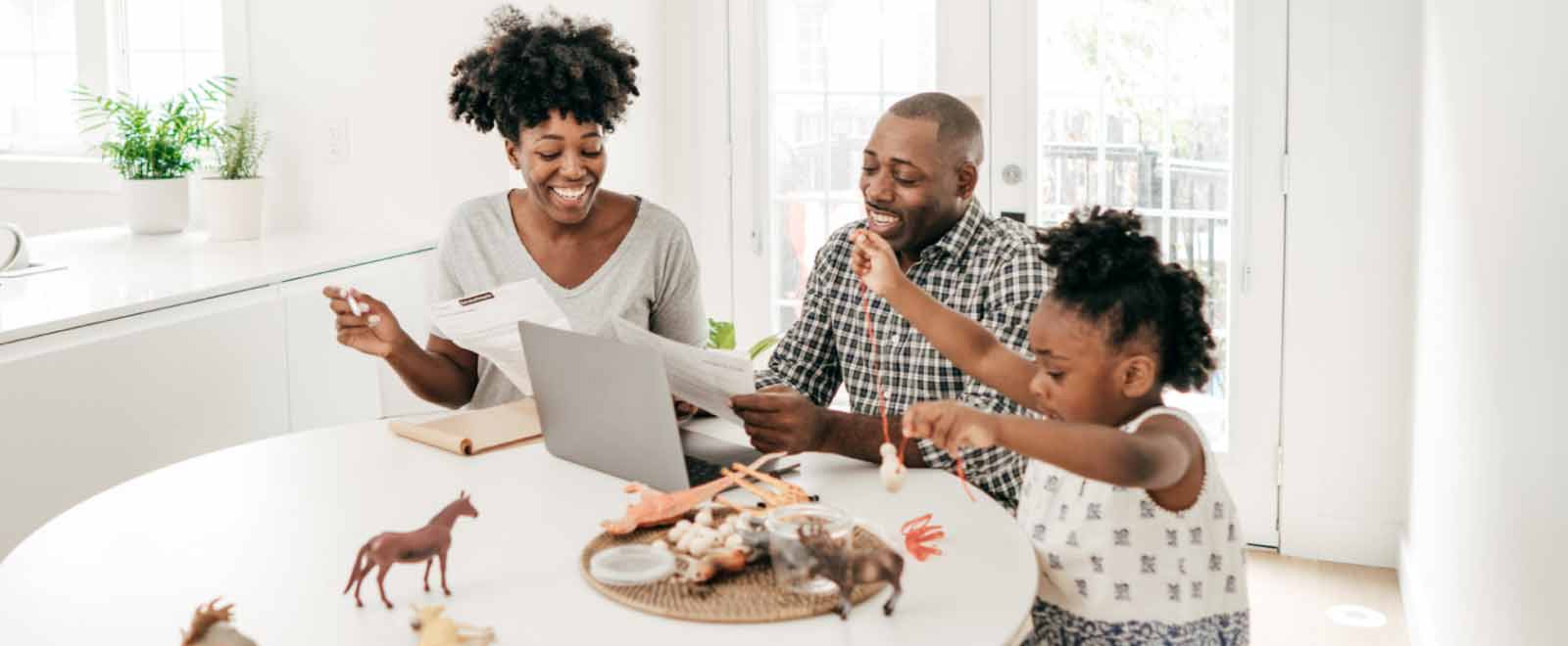 Happy family reviewing finances with a laptop, highlighting the stability and security of a Money Market Account for financial peace of mind.